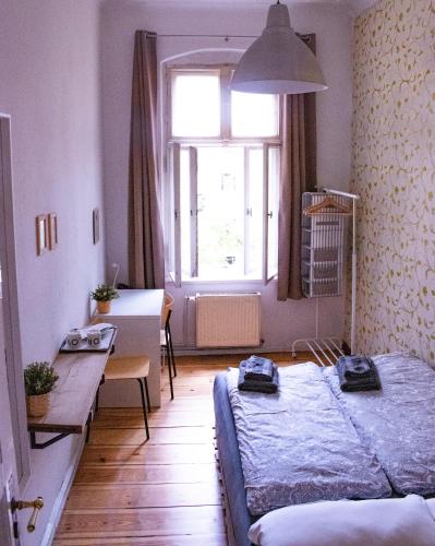a bedroom with a bed and a table and a window at Artsy Room for 2 in Prenzlauer Berg - Ideal Stay in Shared Flat in Berlin