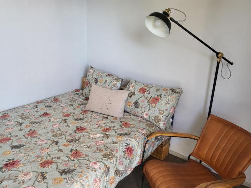 ein Bett mit einem Kissen, einer Lampe und einem Stuhl in der Unterkunft oddih pr Toniqu in Most na Soči