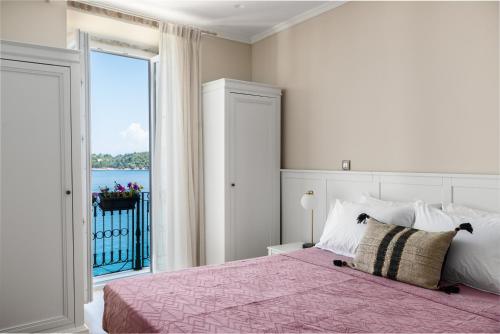 ein Schlafzimmer mit einem Bett und einem großen Fenster in der Unterkunft Fotiadis Family Luxury Suites by Konnect in Korfu-Stadt