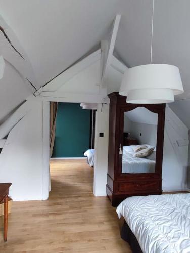 - une chambre avec un miroir et un lit dans l'établissement Le gite des Choiseaux, piscine et parc au cœur de la nature, à Suèvres