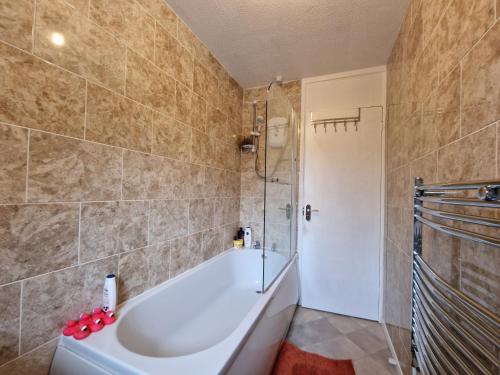 y baño con bañera y ducha. en Nice Living Serviced Accommodations 7 en Rugby
