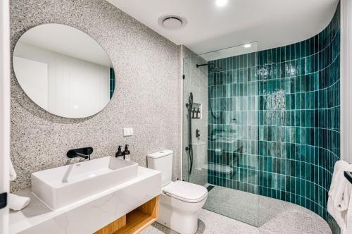 a bathroom with a sink and a toilet and a mirror at Essence Peregian Beach in Peregian Beach