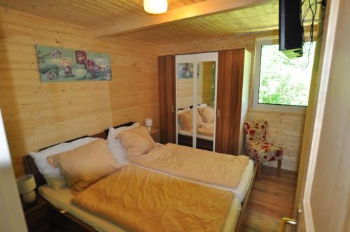 een slaapkamer met een bed in een houten kamer bij Kärnten Appartements in Velden am Wörthersee