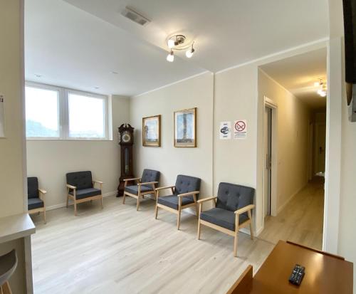 a waiting room with chairs and a table and a clock at Albergo Lodrino in Villa