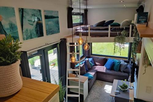 a living room with a couch and a bunk bed at Tiny House Ithblick direkt am See in Salzhemmendorf