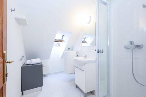 a white bathroom with a sink and a shower at Beethoven Apartments in Bratislava