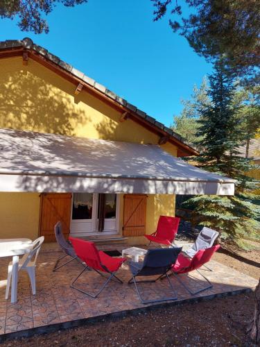 eine Gruppe von Stühlen und einem Tisch vor einem Haus in der Unterkunft Chalet 126 m² PRALOUP in Uvernet