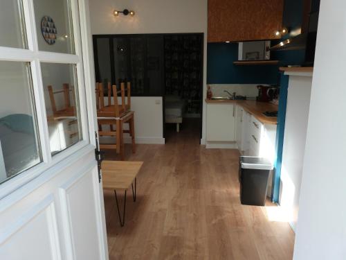 a kitchen with a door and a table and chairs at Le Petit Herbauges in Bouaye