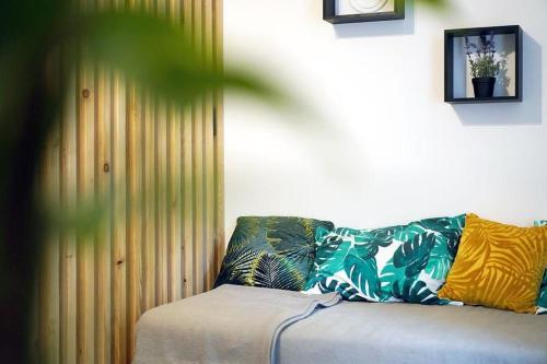 a bed with colorful pillows on it in a room at Apartman Green in Zagreb
