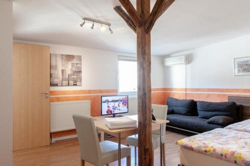 a living room with a bed and a table and a couch at Pension Klingenstr. 23 in Leipzig