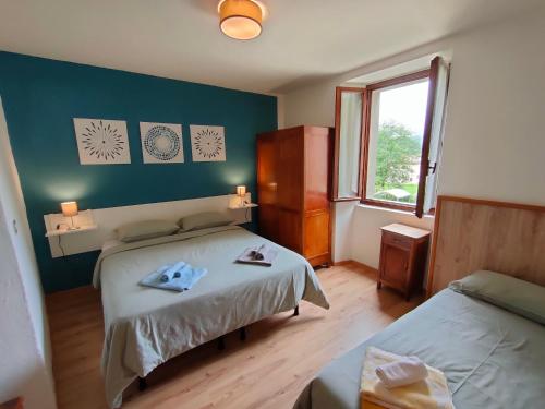 a bedroom with two beds and a window at Casa Maria Angela in Ledro