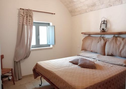 モノーポリにあるTrulli Pietre del Sud Piscina ad uso esclusivoのベッドと窓のある寝室