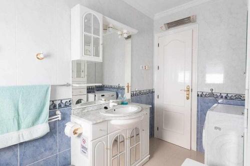 a white bathroom with a sink and a toilet at Villa María con Piscina playa y vistas in Caleta De Velez