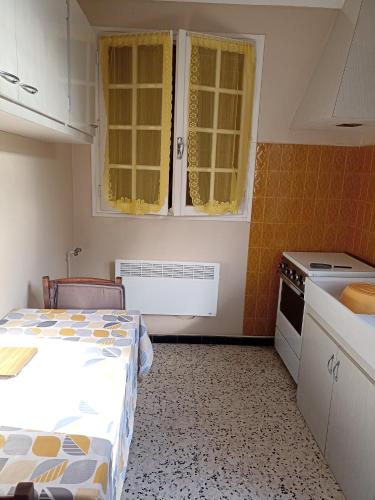 a small kitchen with a bed in a room at T2 à 30 mn de la mer, au pied des montagnes Céret in Céret