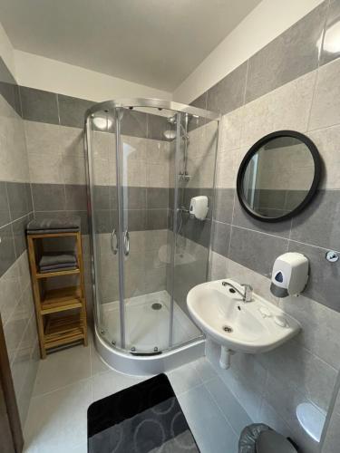 a bathroom with a shower and a sink and a mirror at Ubytovanie HAMAR 17 in Banská Bystrica