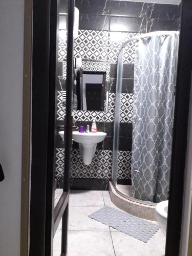 a black and white bathroom with a sink and a shower at Pensiunea Cosalina Grande in Slănic-Moldova