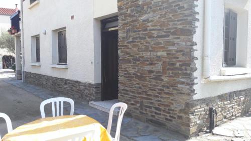 a table and chairs in front of a brick building at T2 à 30 mn de la mer, au pied des montagnes Céret in Céret