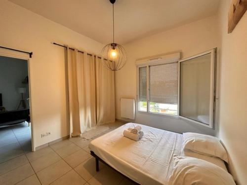 ein Schlafzimmer mit einem weißen Bett und einem Fenster in der Unterkunft Lyon 9 • T2 Porcher • HostisY in Lyon