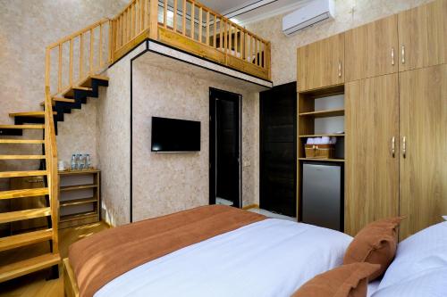 a bedroom with a large bed and a staircase at Hotel Evergreen in Borjomi