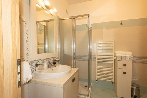 a white bathroom with a sink and a shower at Kiara Residence in Giulianova