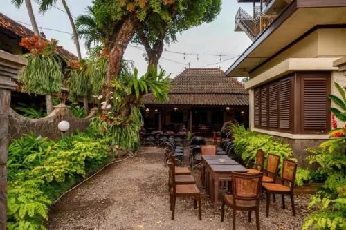 a restaurant with tables and chairs in a courtyard at Cakra Homestay Solo Mitra RedDoorz in Solo