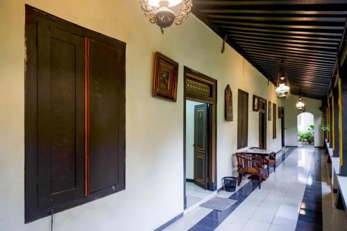 a hallway of a building with a door and chairs at Cakra Homestay Solo Mitra RedDoorz in Solo