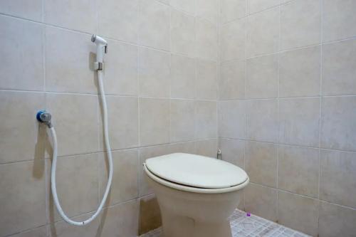 e bagno con servizi igienici e doccia con ugello. di Cakra Homestay Solo Mitra RedDoorz a Solo