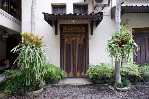 a front door of a house with plants in front of it at Cakra Homestay Solo Mitra RedDoorz in Solo