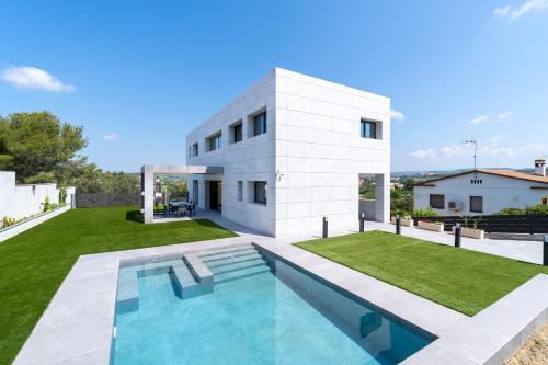 una casa blanca con piscina frente a ella en Altafulla Piscina 4BD Beach BBQ Wifi Portaventura en La Riera