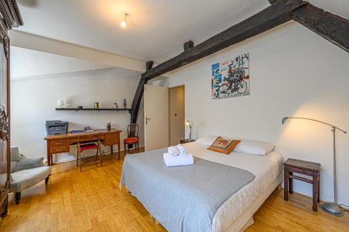 une chambre avec un lit et un bureau dans l'établissement Le Tonkinois - Appartement atypique vue sur le port, à Vannes