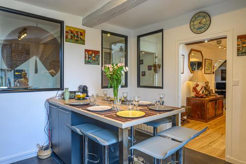 une cuisine avec un îlot bleu, une table et des chaises dans l'établissement Le Tonkinois - Appartement atypique vue sur le port, à Vannes