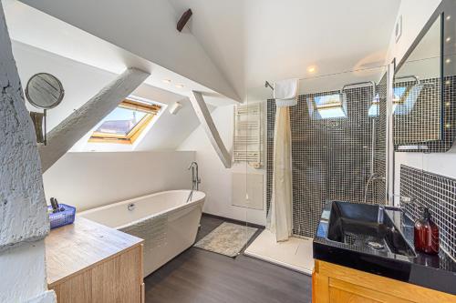 une salle de bain avec un lavabo et une baignoire dans l'établissement Le Tonkinois - Appartement atypique vue sur le port, à Vannes