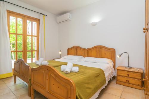 a bedroom with a large bed with two towels at Villa Pastor in Cala Anguila