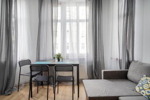 a living room with a table and chairs in front of a window at RentPlanet - Studio Żeromskiego in Wrocław