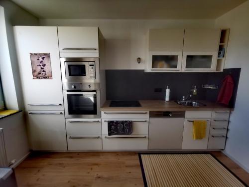 a kitchen with white appliances and a wooden floor at Zentrumsnahe Privatunterkunft Freistadt in Freistadt