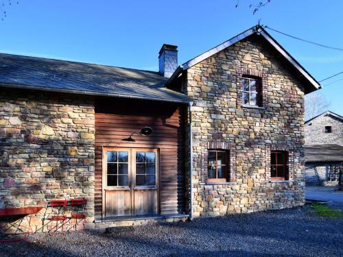 uma antiga casa de pedra com uma porta de madeira em Cozy holiday home in Ennal Grand Halleux em Ennal