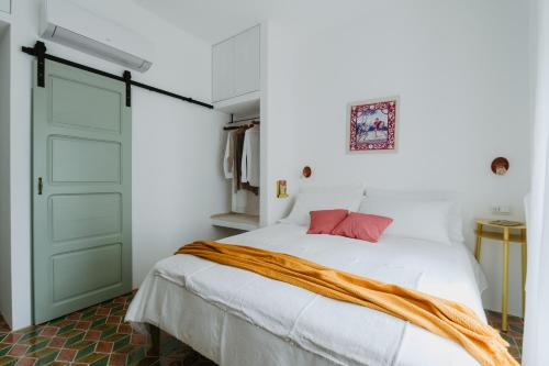 a bedroom with a bed and a green door at Casa Astura in Capo dʼOrlando