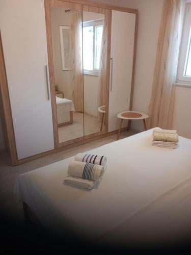a bedroom with a bed with towels and a mirror at Apartment Neve in Veliko Brdo