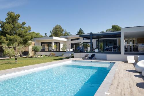 une maison avec une piscine devant une maison dans l'établissement Maison d'Architecte BAIA piscine plein sud Uzès, à Uzès