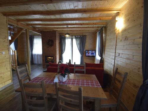 jadalnia z drewnianym stołem i krzesłami w obiekcie Wooden Holiday Home in Skrzynia with Terrace w mieście Osiek