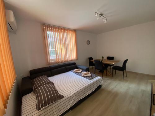 a bedroom with a bed and a table with chairs at Apartamenti Eli in Pomorie