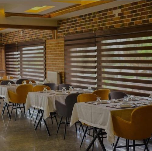 un comedor con mesas y sillas con mantel blanco en Meriç butik otel 