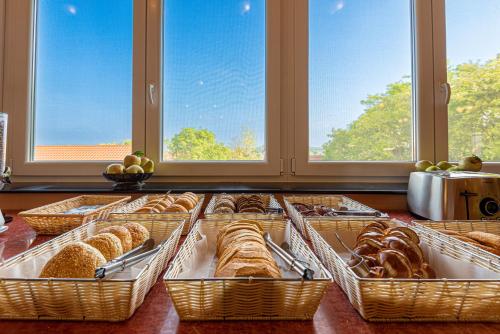 a display of breads and pastries in baskets on a counter at Fried Kastély Hotel Simontornya in Simontornya