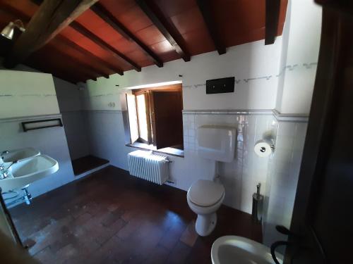 a bathroom with a toilet and a sink and a window at Agriturismo Cà Nova in Palazzuolo sul Senio