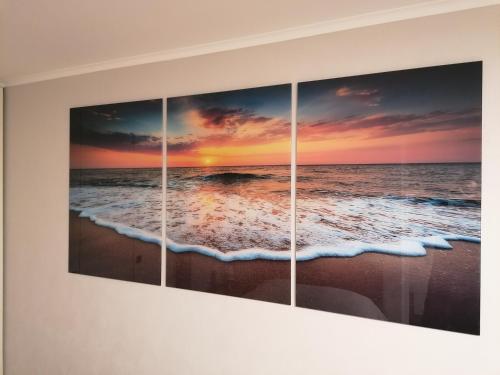 four paintings of the ocean and the beach at Jurmala Kauguri in Jūrmala