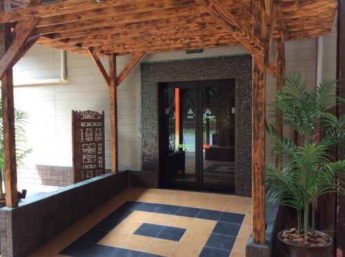 an entrance to a house with a wooden entrance door at HOTEL GEN 福知山店 in Kumohara