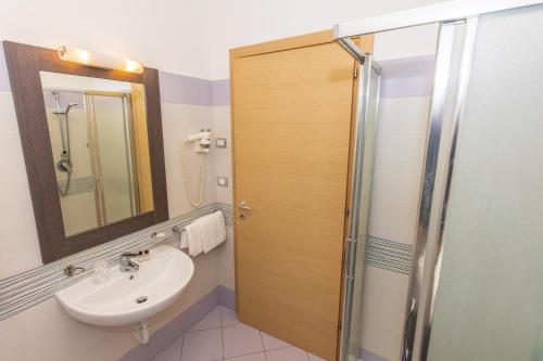 a bathroom with a sink and a shower with a mirror at Kiara Residence in Giulianova