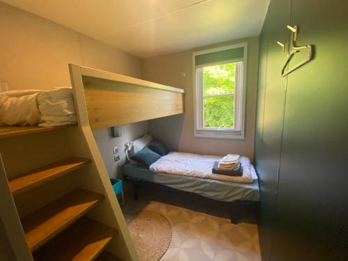 a small bedroom with a bunk bed and a window at Logement Clos des Anges in Ménilles