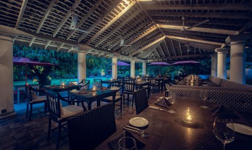 a restaurant with tables and chairs and a pool at Wallawwa in Katunayake