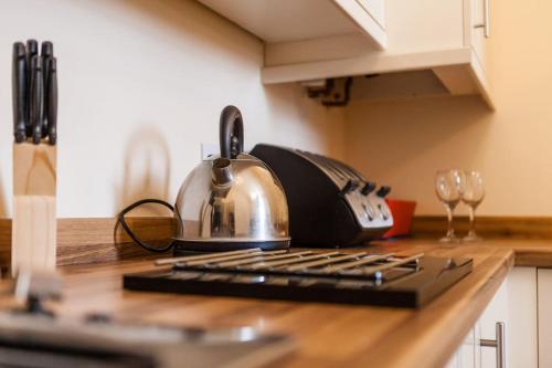 a tea kettle sitting on top of a kitchen counter at Fusilier apartment wrexham city in Wrexham